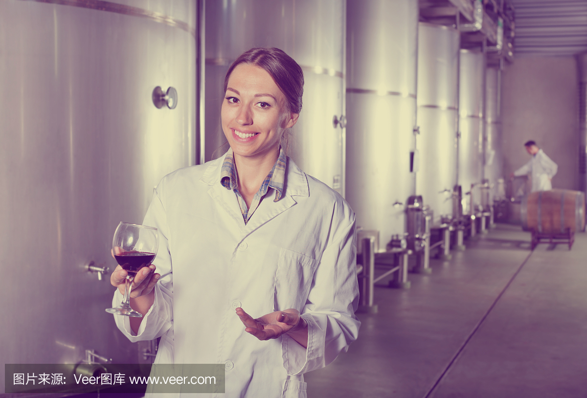 在葡萄酒工厂喝着酒的女人